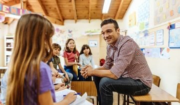Teacher talking to elementary school children and motivates them to learn new subjects